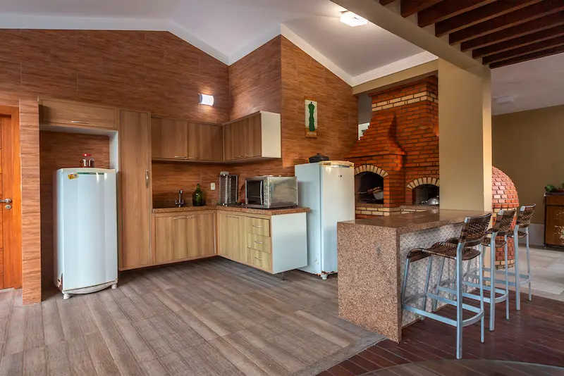 Área gourmet com churrasqueira, forno e bancada, ideal para confraternizações